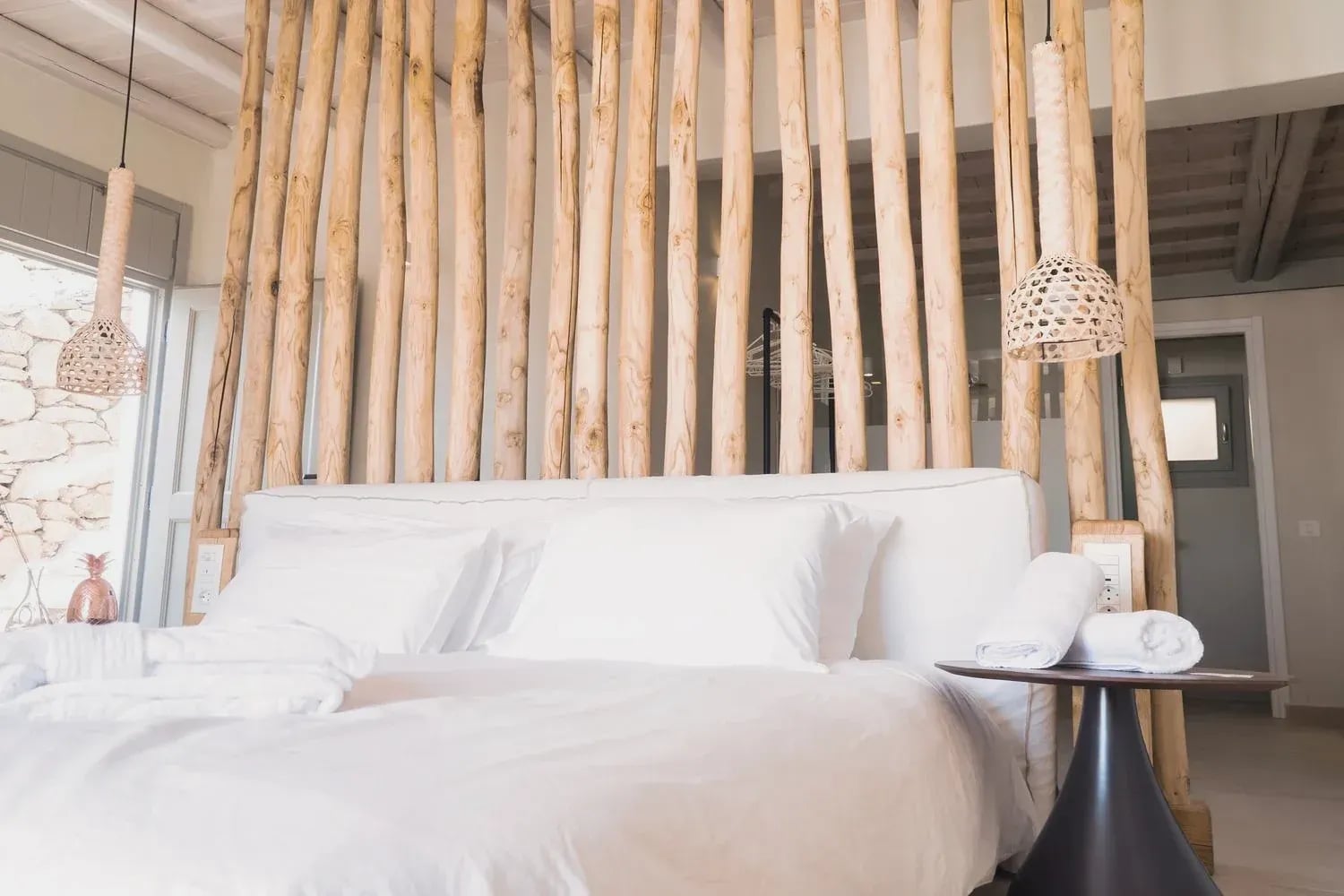 Double bed framed by the driftwood partition in the Deluxe Suite
