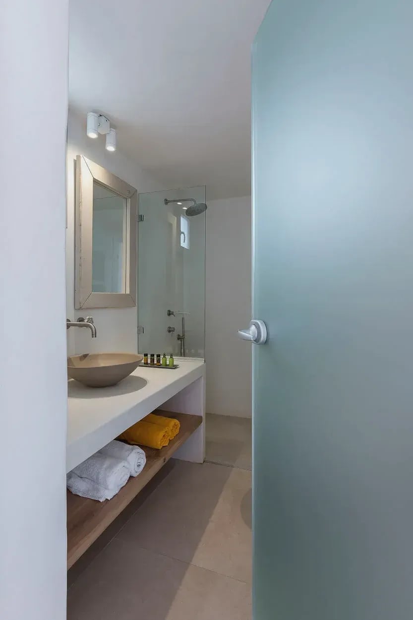 Bathroom with stone basin, floating vanity and frosted glass door