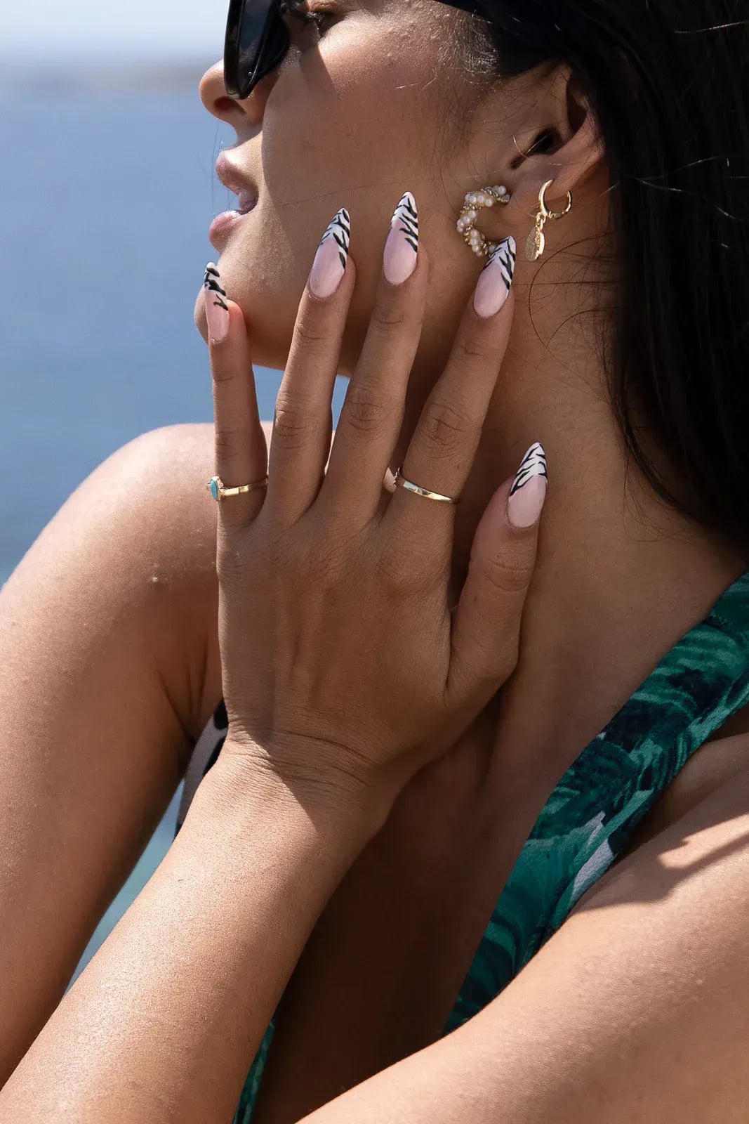 Rings and earrings worn by a guest, the sea out of focus behind