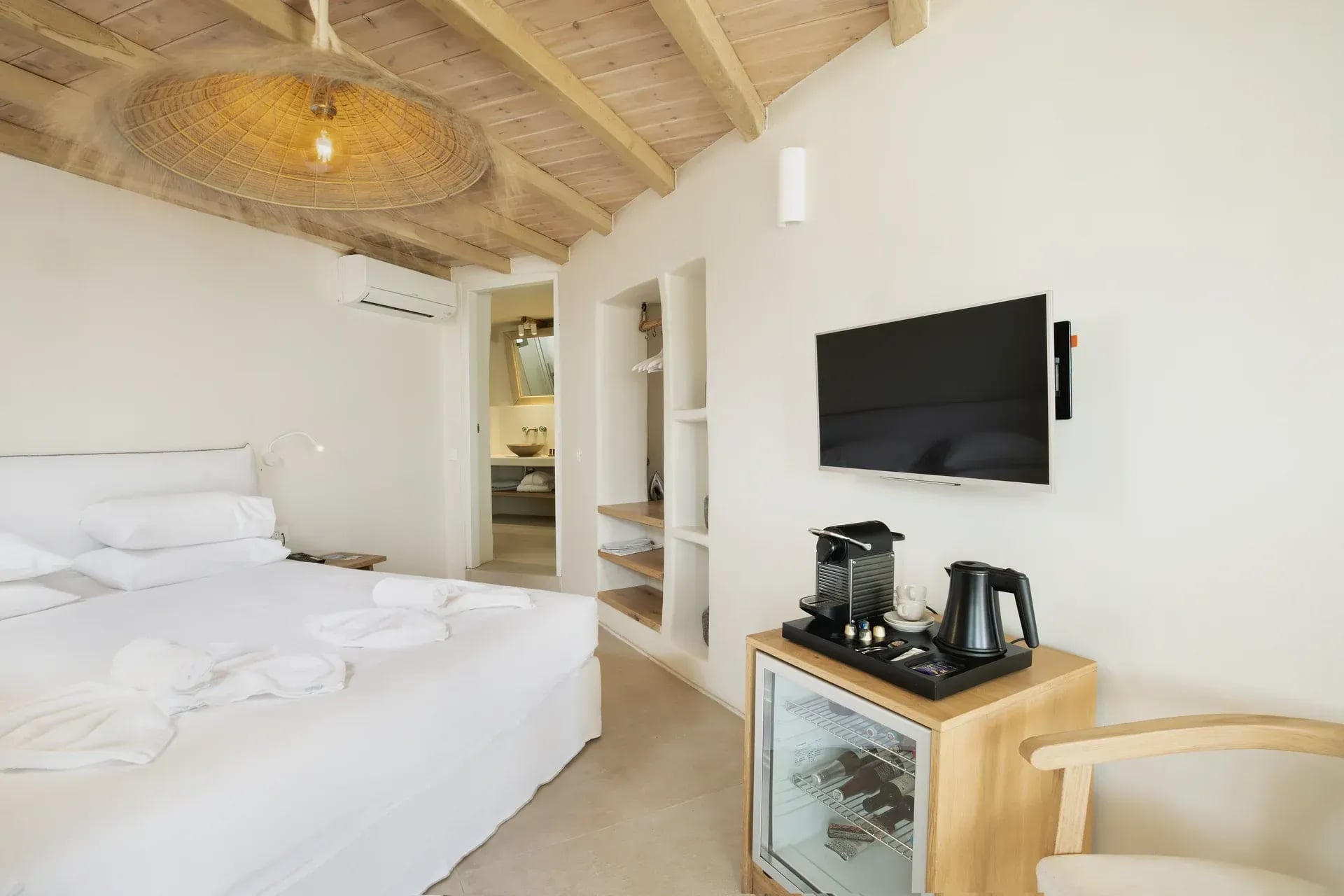 Bed, minibar and television in the Junior Suite bedroom