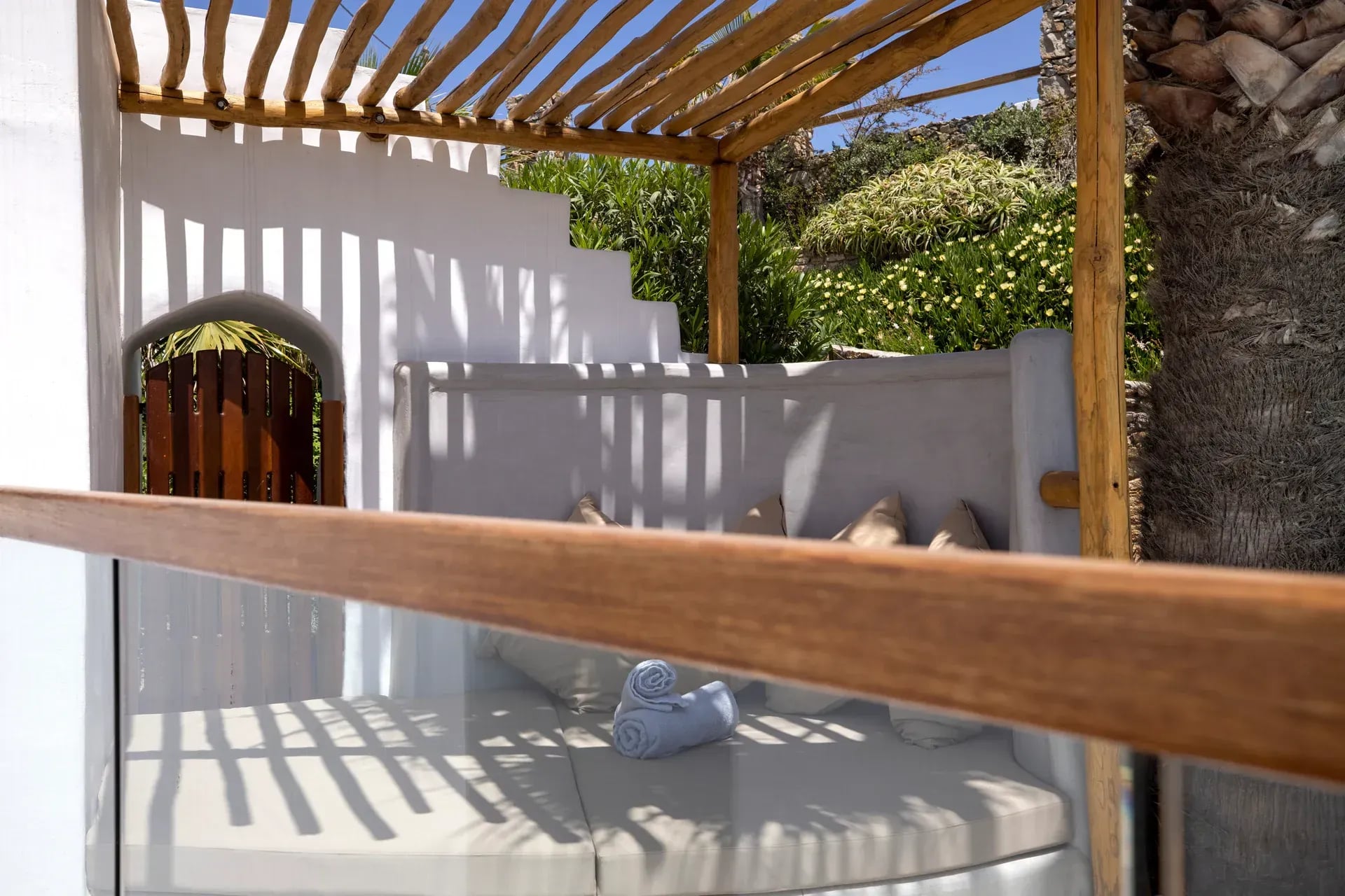 Timber pergola over a whitewashed courtyard and arched doorway