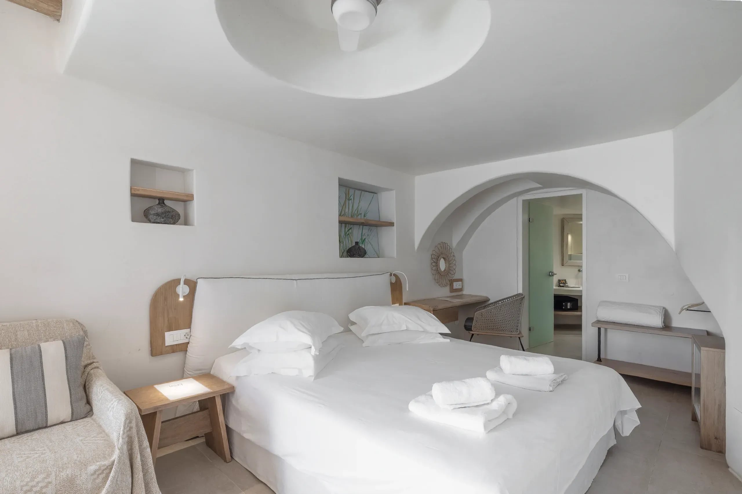 Suite bedroom beneath a domed plaster ceiling, with an arch through to the bathroom
