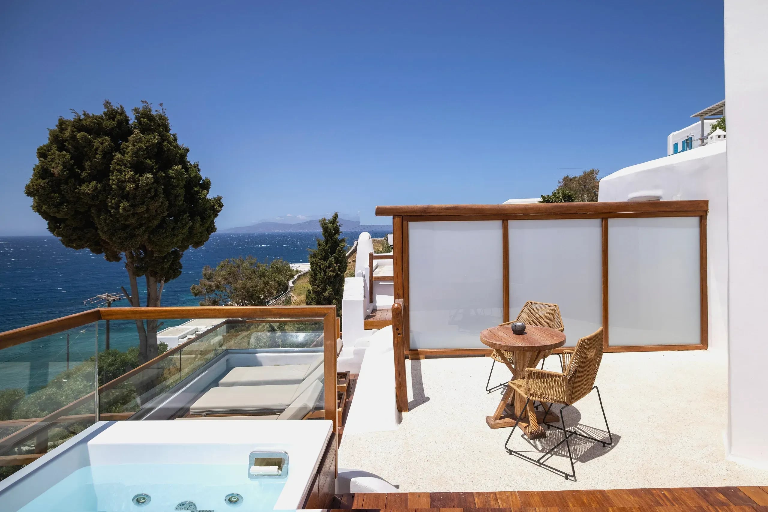 Sun deck of the Superior Suite with outdoor hot tub, seating and the Aegean beyond
