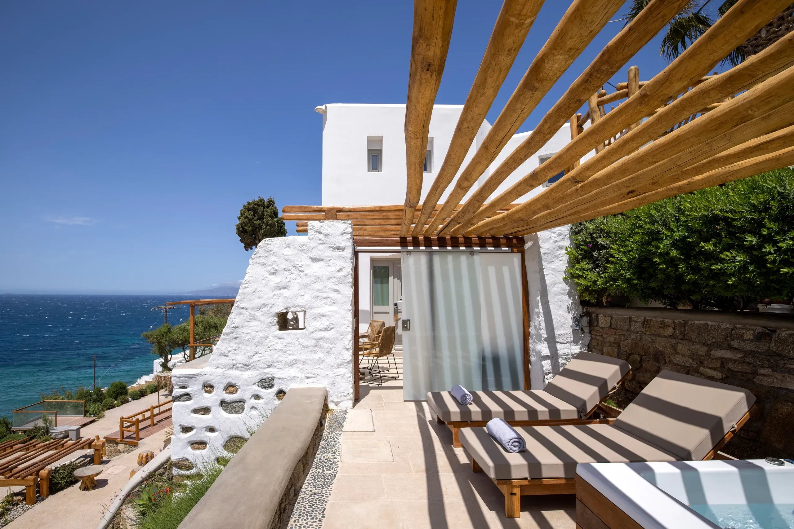 Sun loungers beneath the pergola on the terrace, overlooking the bay