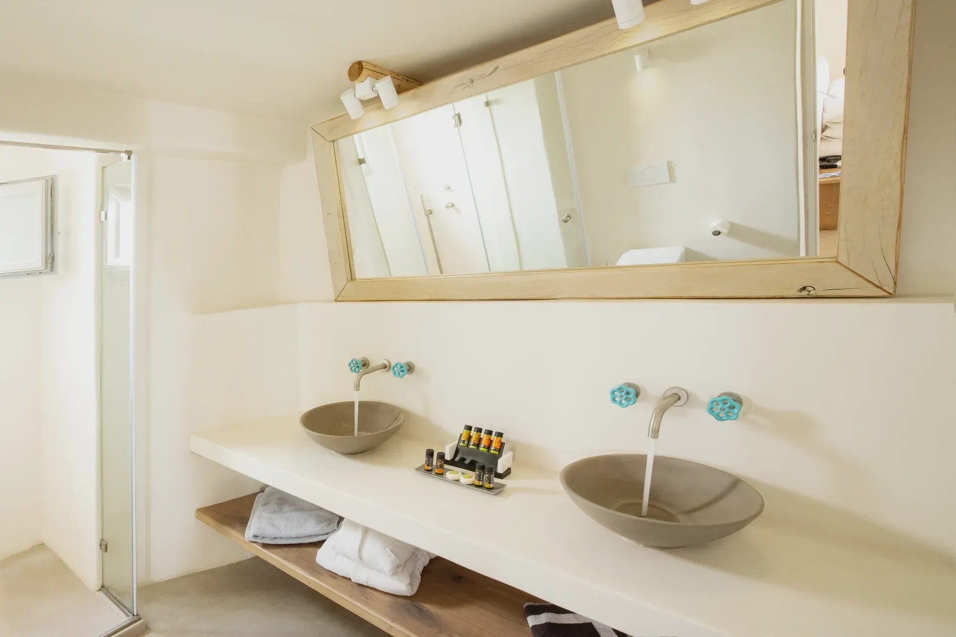 Bathroom with two stone basins beneath a long timber-framed mirror