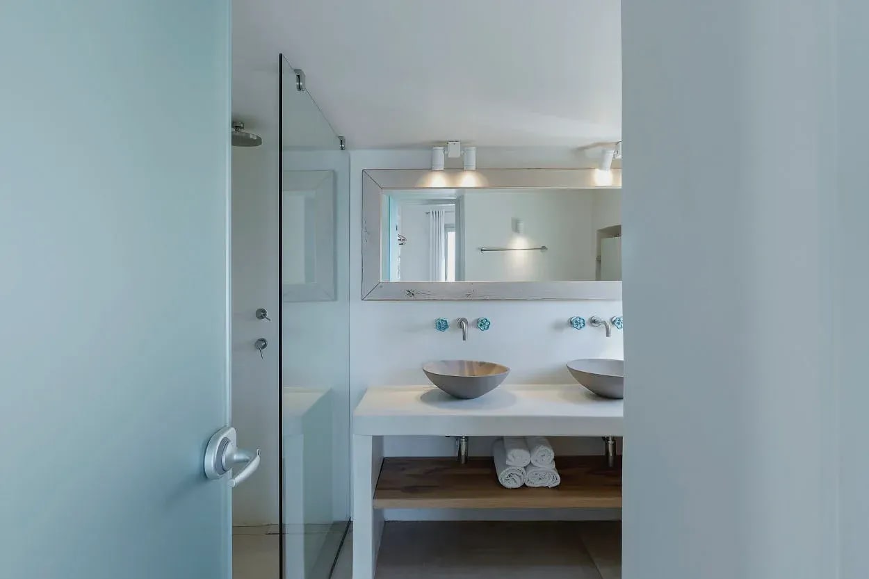 Bathroom with two stone basins and glass shower enclosure
