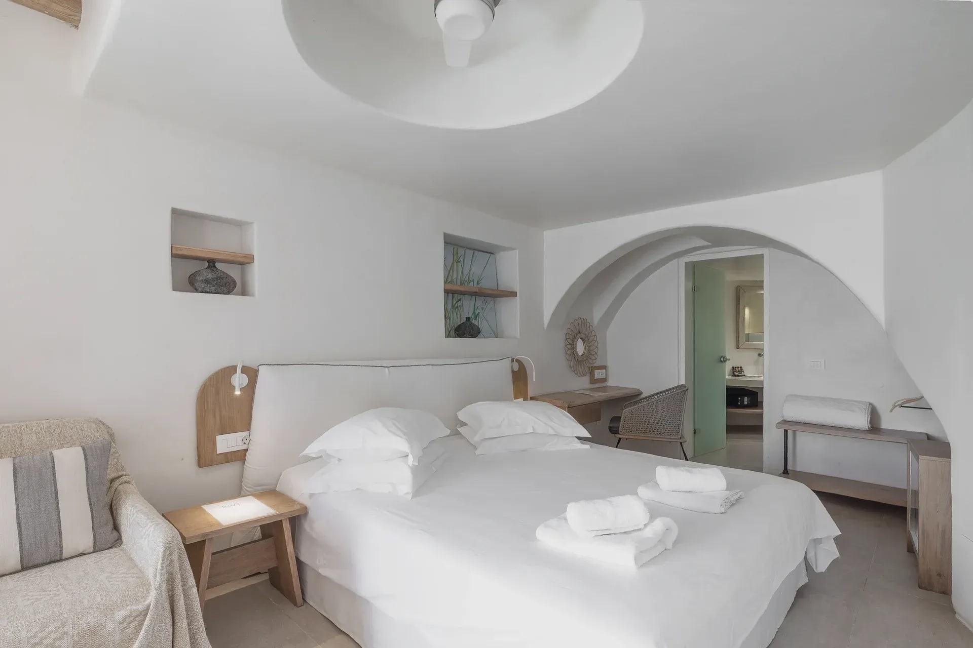 Double bed beneath the domed ceiling recess, arched opening to the bathroom