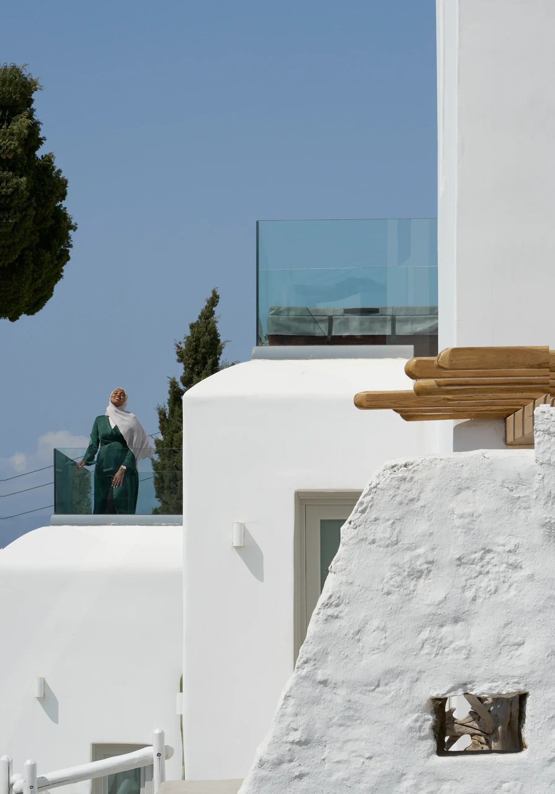 A guest on a terrace among the whitewashed volumes of Legacy Mykonos