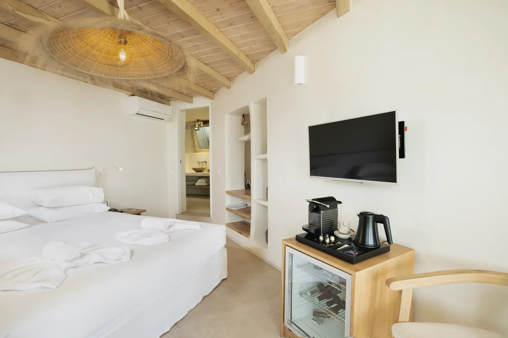 Bed, minibar and television in the Junior Suite bedroom