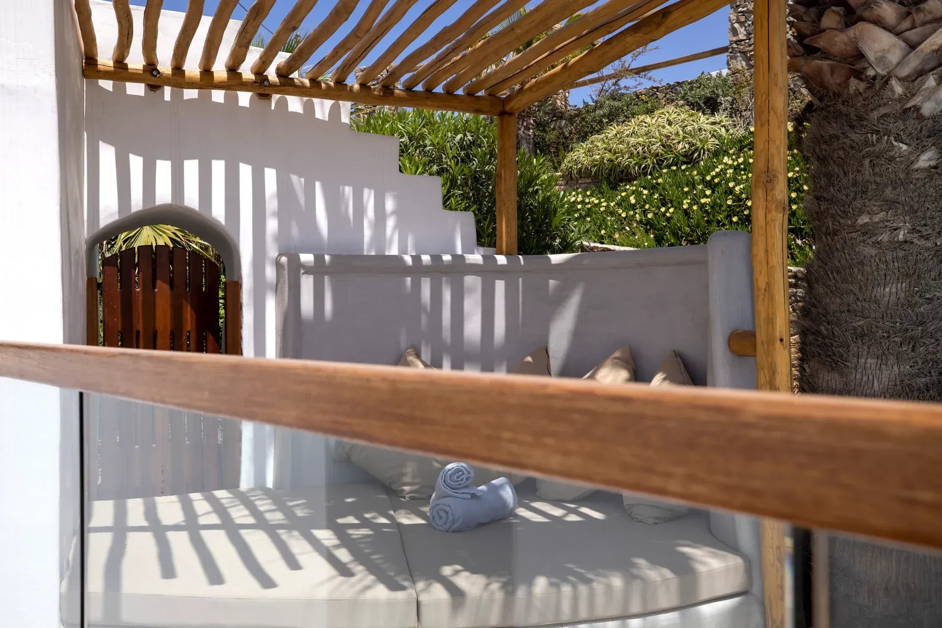 Timber pergola over a whitewashed courtyard and arched doorway