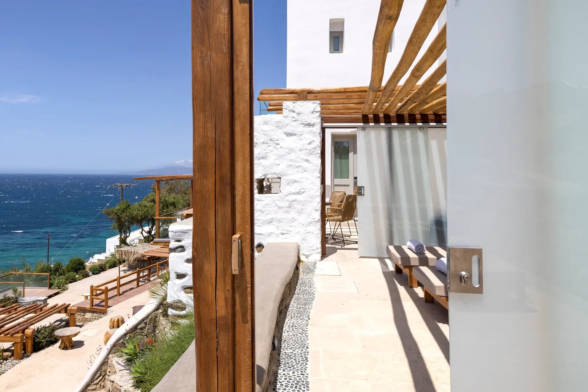 Whitewashed doorway framing the open sea at Legacy Mykonos