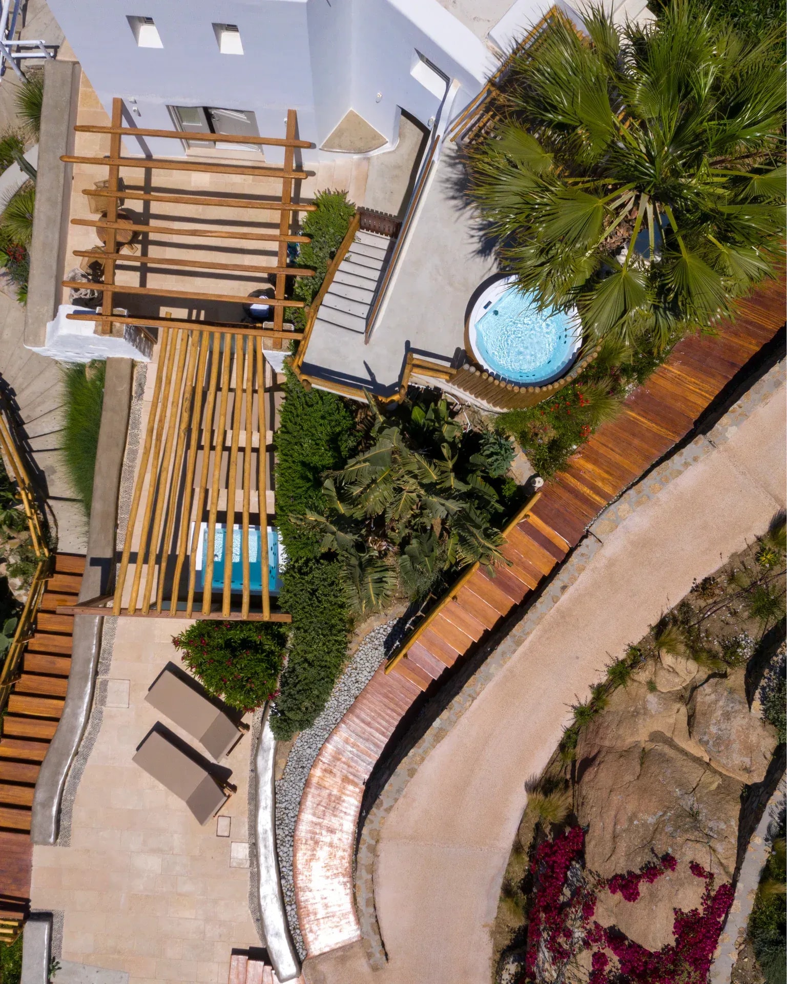 Timber sun decks and planting seen from above, between palms and bougainvillea